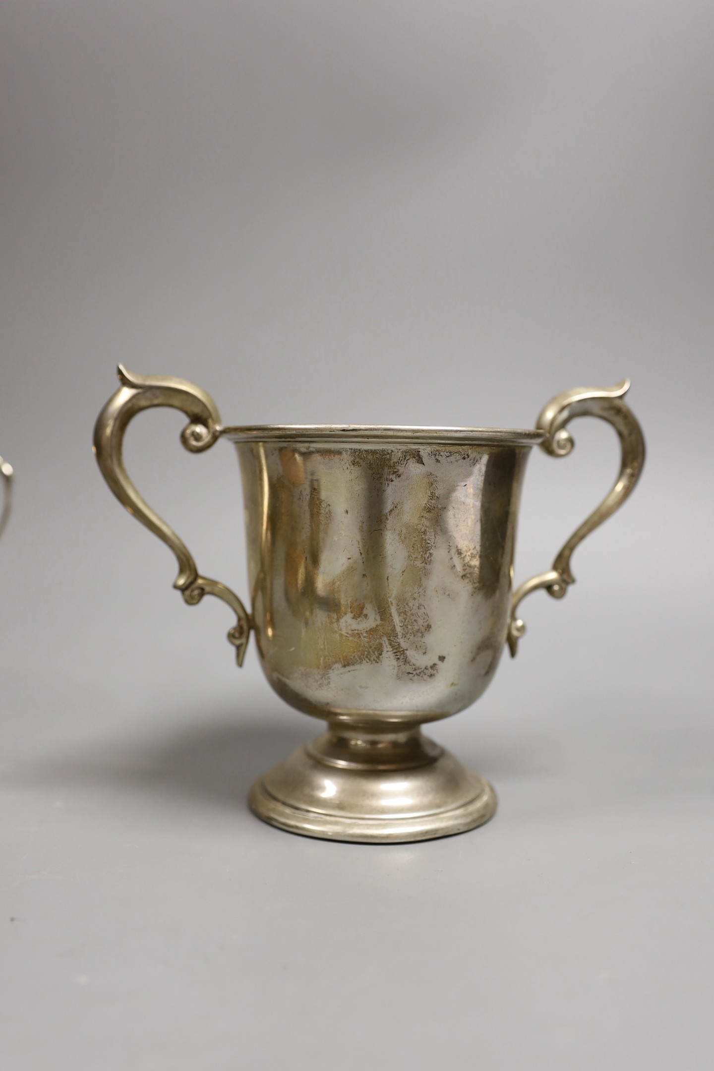 A George V silver two handled pedestal cup, Charles Edwards, London, 1923, height 13.2cm, an Art Deco silver and enamelled hand mirror, Birmingham, 1933, a silver oval trinket box, a silver cream jug and a pair of silver